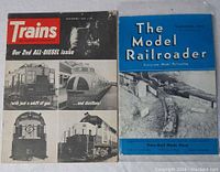 Photo showing two vintage train magazines: 'Trains' December 1949 issue and 'The Model Railroader' September 1949 issue, with visible cover designs and titles.