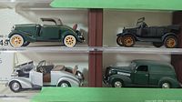 Four Chevrolet diecast model cars displayed on two shelves, showing green Deluxe Roadster, black Model T Touring Car, silver 1937 Cabriolet, and green Sedan Delivery