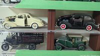 Photo showing four diecast Chevrolet model cars: cream 1938 Master Deluxe Coupe, black 1936 Standard Town Sedan, black 1923 Series D 1 Ton Truck, green 1928 Imperial Landau with beige roof