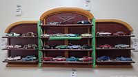 Front view of the three-piece wood display shelf filled with model cars, showing the central piece with 'The Classic Cars of The Fifties' emblem.