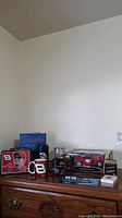 Wide view of all items including lunchbox, mugs, magnets, cards, model car box arranged on dresser
