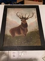 Antique painting of a brown stag with large antlers in natural setting, framed in simple black frame.