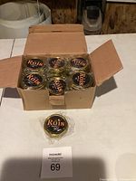 Box of 24 new gold tin Röis candles arranged in rows, unopened in original packaging.