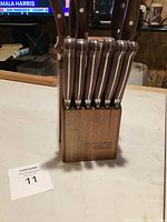 Photo showing the wooden storage block with seven kitchen knives inserted, the block is engraved with the Wusthof logo and brand name