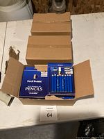 Box opened to show multiple packs of 8 pencils with eraser and sharpener in blue packaging labeled Pencil Buddies kids triangular pencils.
