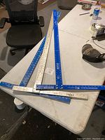 Three T-squares laid on a table showing their lengths and condition, one branded Mayes.