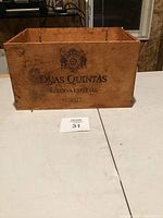 Wooden crate with 'DUAS QUINTAS RESERVA ESPECIAL 2003' and crest logo printed on one side.