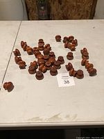 Multiple vintage wooden knobs spread on a table, showing quantity and condition.