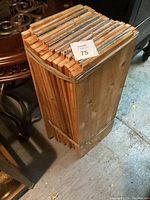 Bundled 13 wooden shelves viewed from the top showing thickness and wood grain, packed with rubber bands.