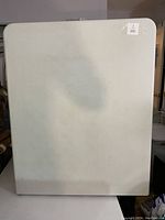 Top view of the 6 ft white folding table surface, showing a somewhat soiled and plain rectangular tabletop.