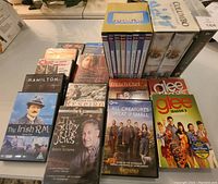 Top view of assorted DVDs on flat surface showing titles and packaging types.