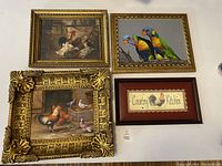 Four framed bird artworks including roosters, pigeons, parrots and a country kitchen sign, displayed grouped on a surface.