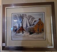 Framed limited edition print showing a winter village scene with snow, houses, trees, and church steeple, signed by C. Gagnon.