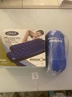 Photo of Airest Inflatable Bed 2-Pack box with image of blue inflatable bed and Klymit Versa Blanket in plastic packaging.