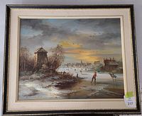 Framed oil on canvas painting showing winter scene with people skating on canal, town buildings, and sunset sky.