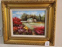 Framed original oil painting showing a colorful garden with flowers and houses, in an ornate gold frame.