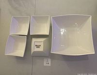 Top view of set including one large square bowl and four smaller square bowls arranged with bottoms showing on some and fronts on others.