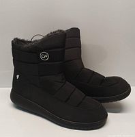 Side view of both boots showing quilted black exterior, logo patch, and rubber sole.