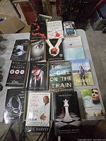 Photo of 16 books spread out on a table showing front covers including fiction, memoirs, and self-help titles.