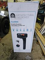 Photo of new, boxed Architectural Mailboxes Classic black plastic mailbox and post kit showing model details and features on the packaging.