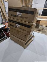 Four unopened cardboard boxes stacked containing Torna brand hangers labeled 'The Finest Hanger'.