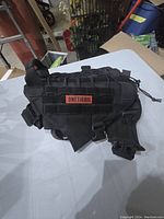 Side view photo of black medium dog harness showing adjustable straps, buckle clips, and brand label patch.