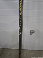 Close-up of the mid-shaft showing Warrior ALPHA DX4 branding in gold and black.