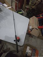 Full length view of Zebco youth fishing rod laid on table showing entire rod and reel.