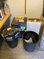 Photo showing the Aquascape PondMax filter unit with kits and filter media in buckets alongside product packaging and test kit.