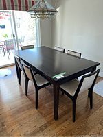 Angled view of dark wood table with six chairs arranged
