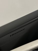 Close-up photo of the white Hisense branding on the chest freezer lid area showing minor surface wear.