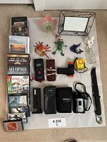 Full layout of all items including DVDs, binoculars, figurines, knife, cases, and other household items.