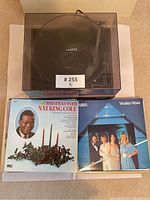 Lloyd's record player with dust cover closed, two vinyl albums including Nat King Cole Christmas and ABBA Voulez-Vous visible in view