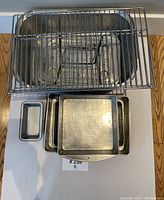Top view showing metal grill rack on top of various baking pans including a square and a small loaf pan.