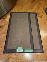 Two anti-fatigue floor mats stacked showing size and surface texture.