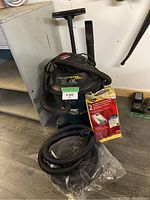 Shop-Vac Ultra Blower wet/dry vacuum with hose, attachments, and bag pack on floor.