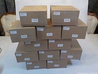 Stack of 12 labeled brown cardboard boxes containing the LED pot lights.