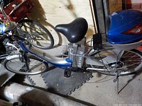 Full side view of the silver and blue Daymak electric bike showing frame, seat, front basket, rear box and charger.