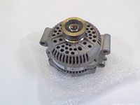 Front angled view of the rebuilt alternator showing the pulley and ventilation holes on the metal casing, placed on bubble wrap.