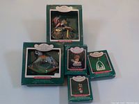 Five Hallmark Christmas collector edition ornaments in original boxes including one special edition Santa riding bicycle.