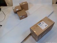 Photo of four boxed lights and one long LED panel light showing the variety of items in the lot