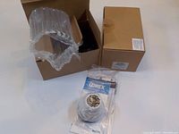 Two cardboard boxes, one partially opened showing a plastic-wrapped Dome camera and instruction manual with Lorex branding included.