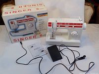 Full lot with Singer sewing machine, foot pedal, instruction manual, and retail box.