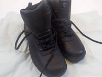 Pair of black Timberland tactical boots seen from an angled front view showing laces and padded collar.