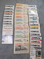 Top view showing multiple issues of Toronto Computes magazine with various colored text on white backgrounds, stacked vertically, showcasing publication name clearly