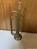 Front view of brass bugle horn showing coiled tubing, bell, and mouthpiece.