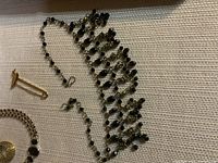 Photo of black beaded necklace with dangling elements and gold-tone chain pieces