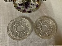 Two pressed glass dishes with detailed pattern and scalloped edges