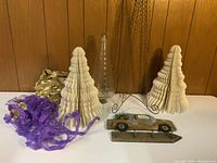 Holiday lot displayed against wood-paneled wall including ceramic trees, wire trees, purple garland, clear cone ornament, and wooden car ornament.