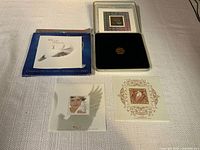 Full view of the coin in a display case, blue celebration year 2000 booklet, and two mounted Canadian stamps